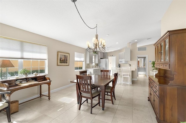 4951 Corsica Sq, Vero Beach, FL 32967 - dining room featuring a chandelier, light tile patterned flooring, and a textured ceiling