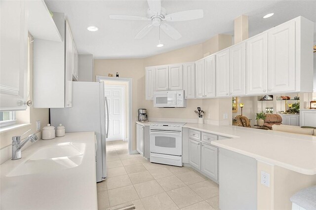 4951 Corsica Sq, Vero Beach, FL 32967 - kitchen featuring white appliances, a peninsula, light tile patterned flooring, white cabinets, and a ceiling fan