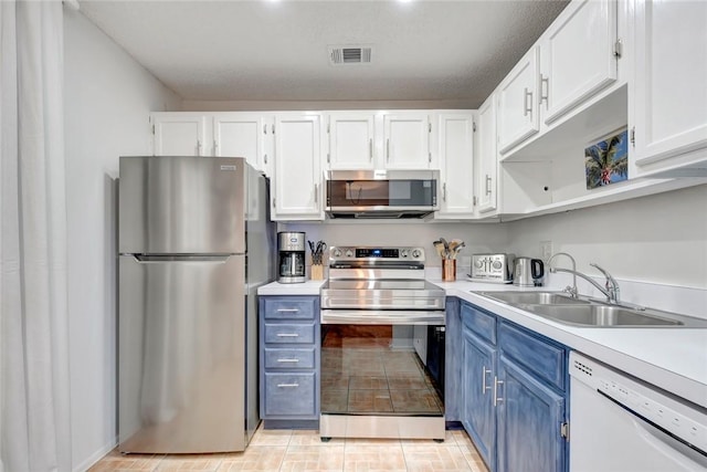 kitchen featuring sink, blue cabinets, stainless steel appliances, and white cabinetry