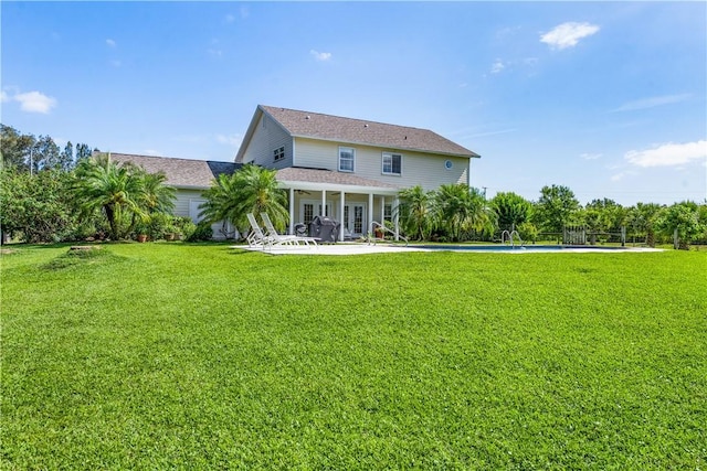 7387 61st St, Vero Beach, FL 32967 - back of property with a lawn, a patio area, and roof with shingles