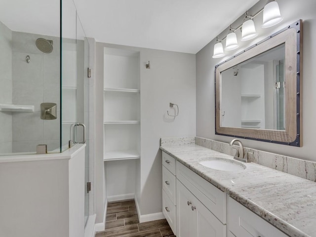 bathroom with a shower with door and vanity