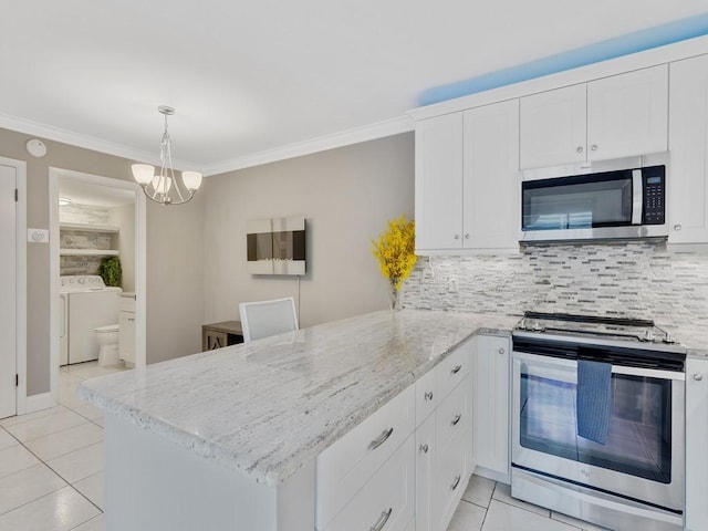 kitchen featuring appliances with stainless steel finishes, washer and dryer, white cabinets, and kitchen peninsula