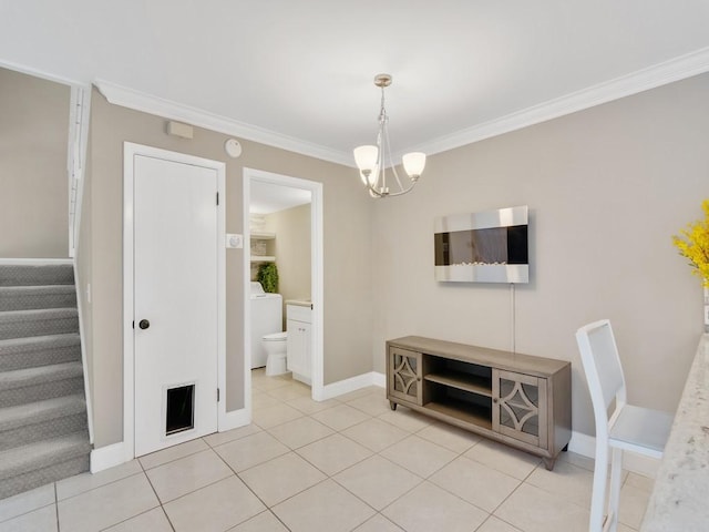 dining room with washer / clothes dryer, crown molding, light tile patterned floors, and a notable chandelier