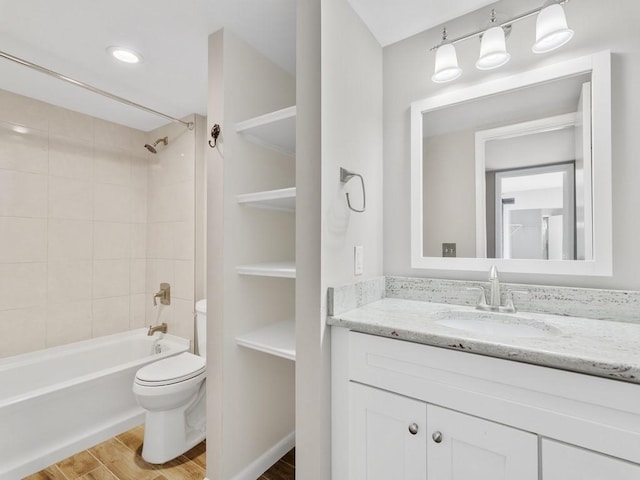 full bathroom with tiled shower / bath combo, wood-type flooring, vanity, and toilet