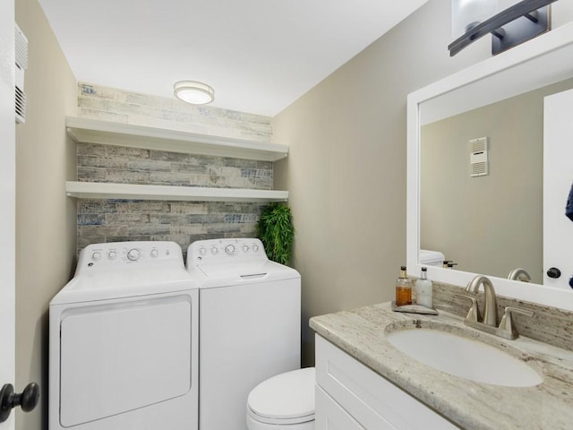 bathroom with vanity, independent washer and dryer, and toilet