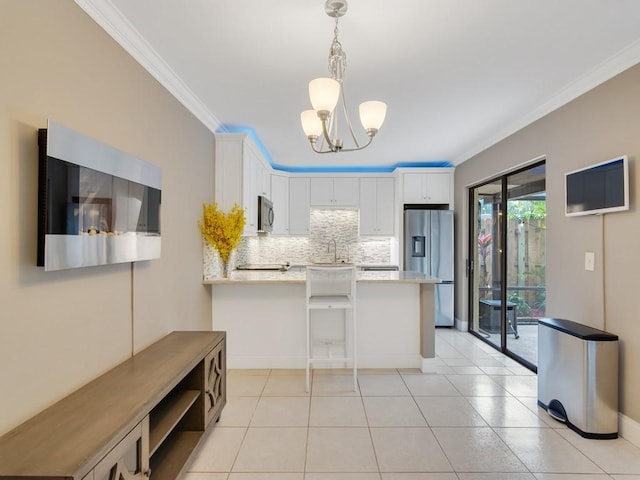 kitchen with white cabinetry, decorative backsplash, ornamental molding, stainless steel appliances, and light stone countertops