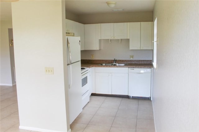 kitchen with white appliances, light tile patterned flooring, a sink, and white cabinetry