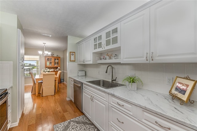 kitchen with light hardwood / wood-style floors, sink, tasteful backsplash, white cabinetry, and appliances with stainless steel finishes