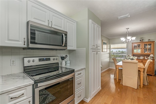 kitchen featuring white cabinetry, stainless steel appliances, light hardwood / wood-style flooring, and an inviting chandelier