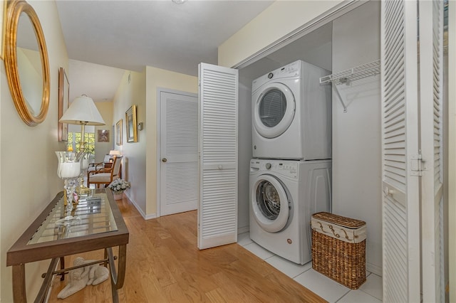 washroom featuring light hardwood / wood-style flooring and stacked washer / drying machine