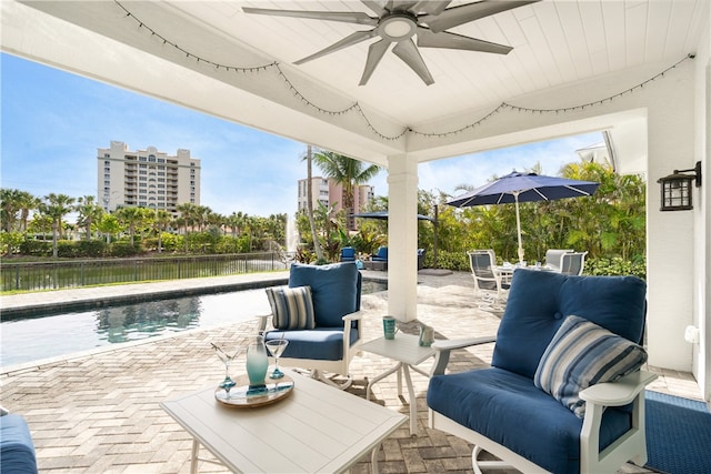 view of patio / terrace featuring a fenced in pool, an outdoor hangout area, a water view, and ceiling fan