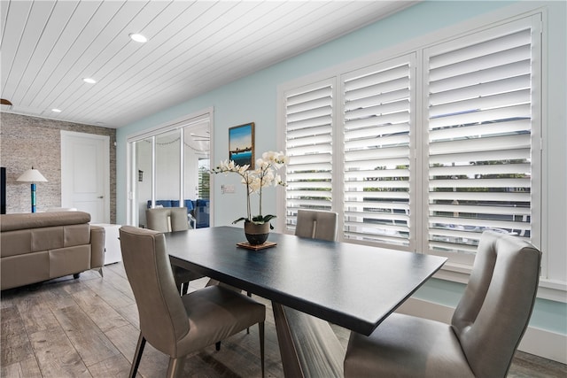 dining area with a wealth of natural light, light hardwood / wood-style floors, and wood ceiling