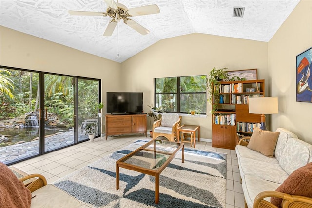 tiled living room with plenty of natural light, vaulted ceiling, and a textured ceiling