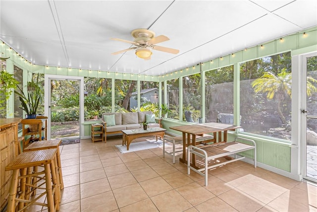 sunroom / solarium featuring a ceiling fan