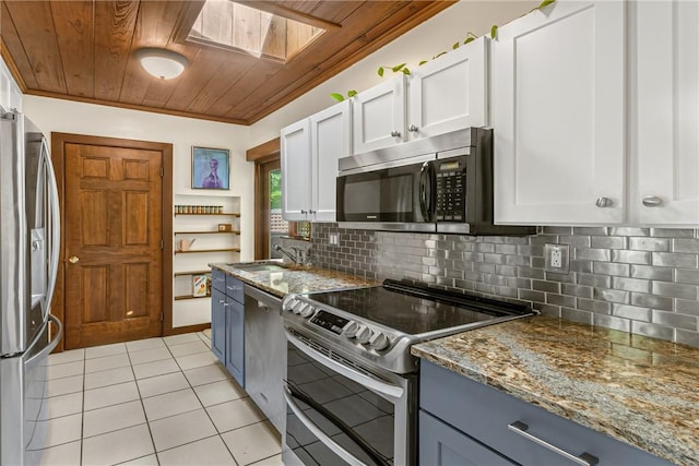 kitchen featuring stainless steel appliances, a skylight, a sink, wood ceiling, and decorative backsplash