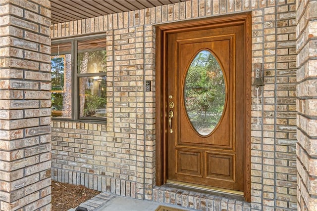 view of exterior entry featuring brick siding