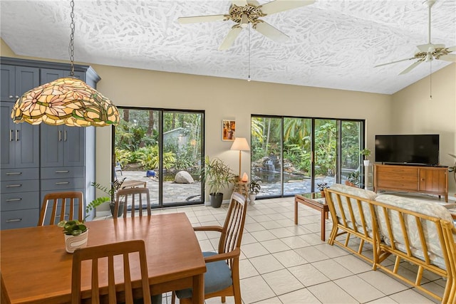 dining room with light tile patterned floors, ceiling fan, vaulted ceiling, and a healthy amount of sunlight