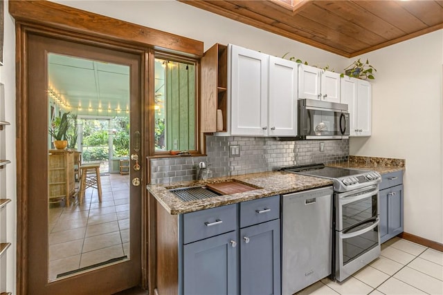 kitchen with stainless steel appliances, white cabinets, a sink, and decorative backsplash