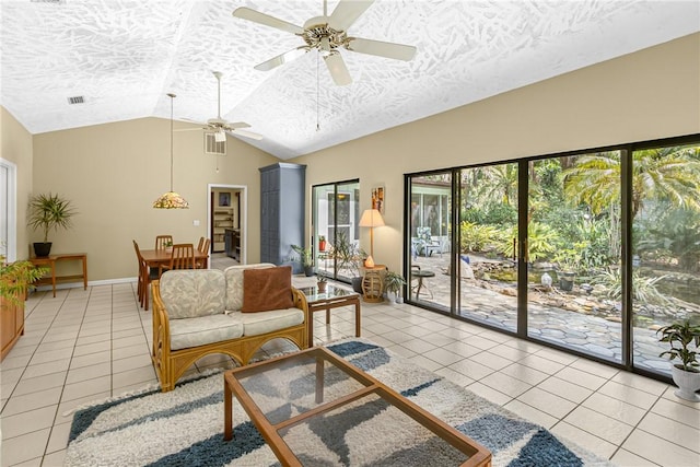 living area featuring light tile patterned floors, a textured ceiling, visible vents, a ceiling fan, and vaulted ceiling