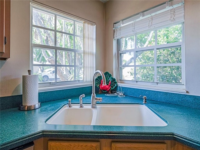 kitchen featuring a sink, brown cabinets, and dark countertops