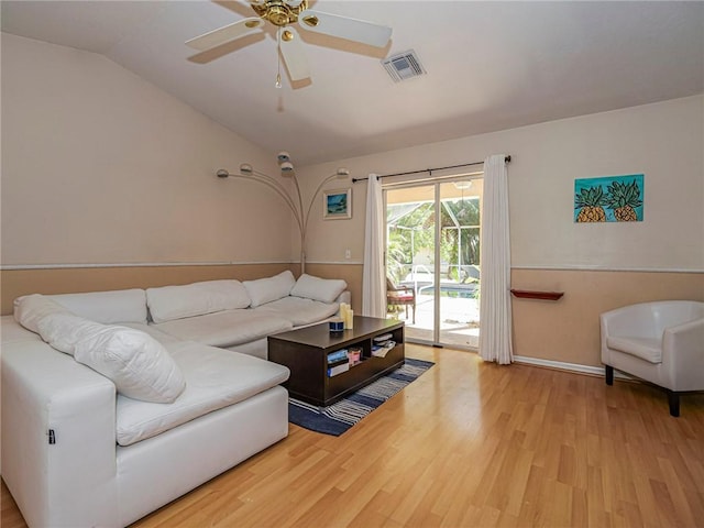 living room with vaulted ceiling, wood finished floors, visible vents, and ceiling fan