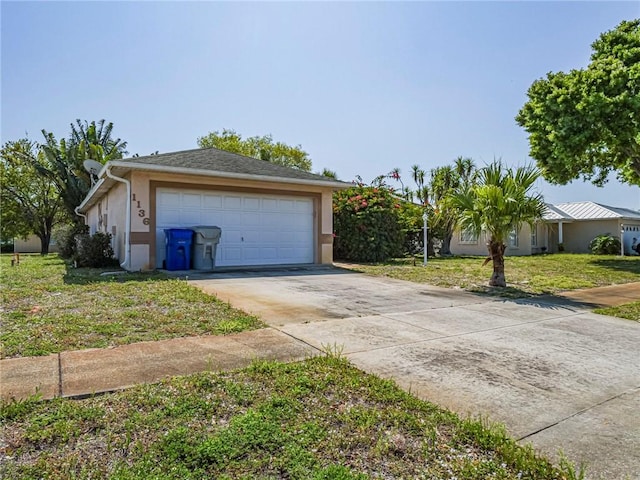 view of front of home featuring a front yard, a garage, and stucco siding