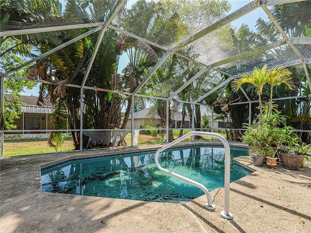 view of pool with a patio area, glass enclosure, and a fenced in pool