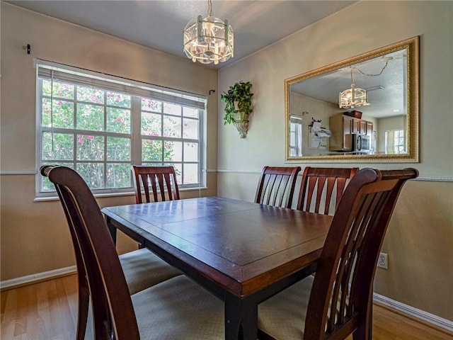 dining space with baseboards and wood finished floors