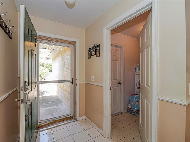 doorway with baseboards and light floors