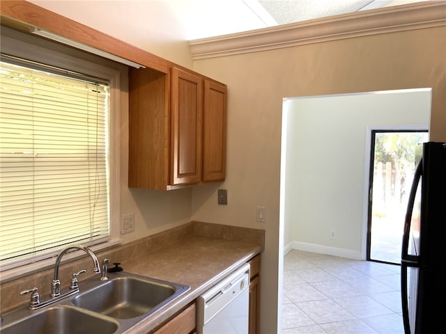 kitchen featuring sink, black refrigerator, white dishwasher, and light tile patterned floors