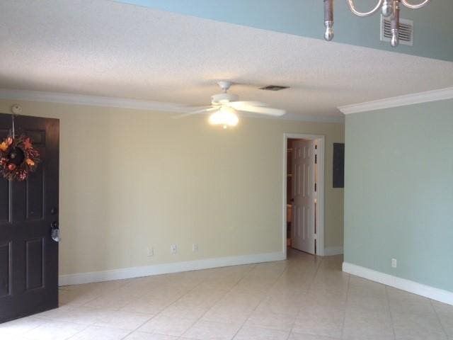 tiled empty room with ceiling fan and ornamental molding