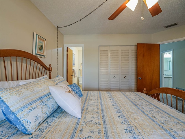 bedroom with a closet, a textured ceiling, ceiling fan, and ensuite bath