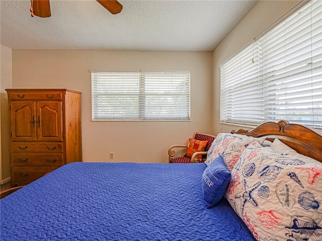 bedroom with a textured ceiling and ceiling fan