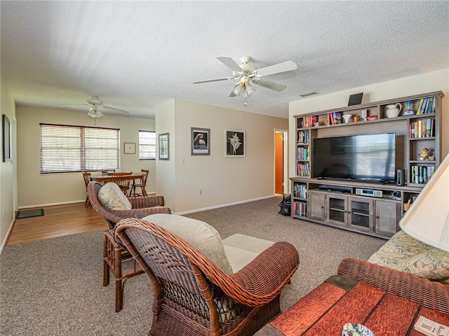 living room with a textured ceiling, hardwood / wood-style flooring, and ceiling fan