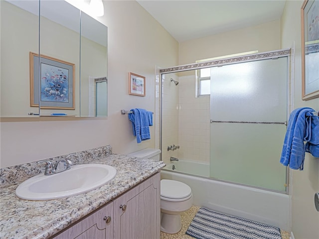 full bathroom featuring shower / bath combination with glass door, tile patterned floors, vanity, and toilet