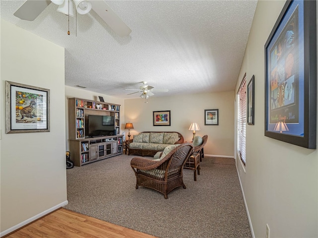 living room with hardwood / wood-style flooring, ceiling fan, and a textured ceiling