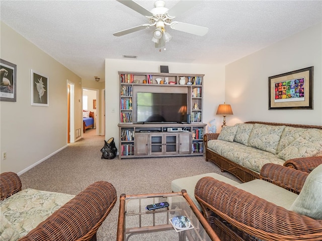 carpeted living room with ceiling fan and a textured ceiling