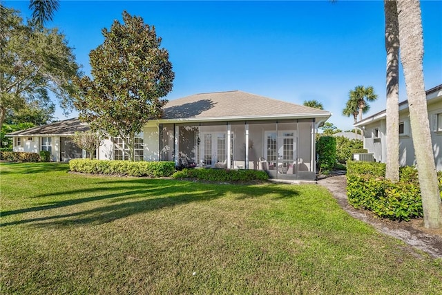 rear view of property featuring a lawn, central air condition unit, and a sunroom