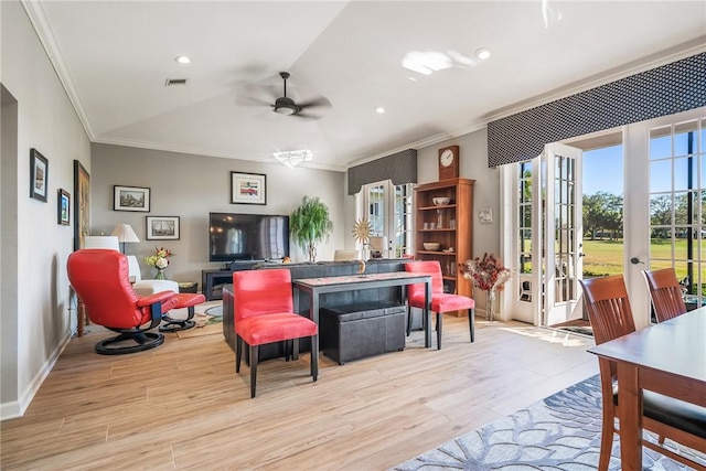 living room with ceiling fan, light wood-type flooring, crown molding, and french doors