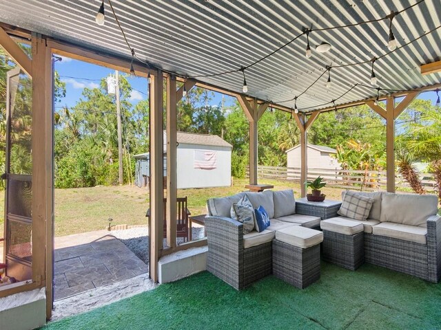 view of patio / terrace with an outdoor structure, a shed, fence, and an outdoor living space