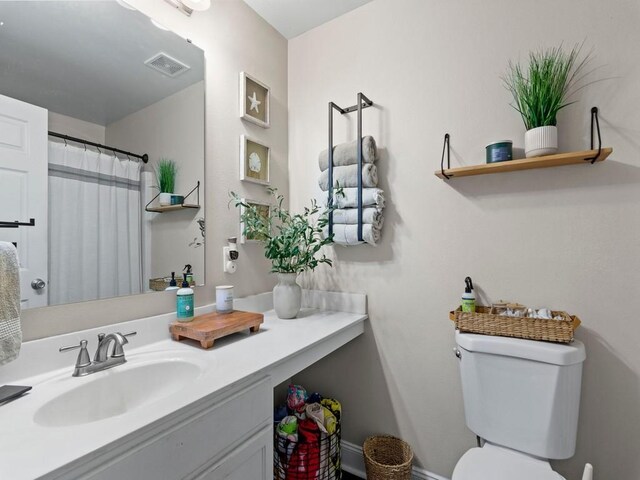 bathroom with visible vents, vanity, a shower with shower curtain, and toilet
