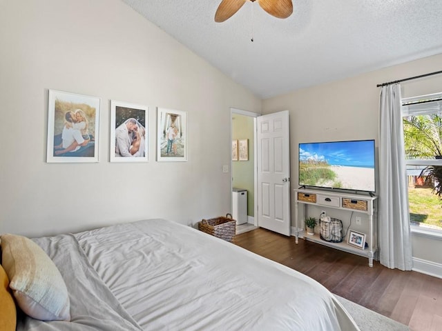 bedroom with vaulted ceiling, wood finished floors, a ceiling fan, baseboards, and a textured ceiling