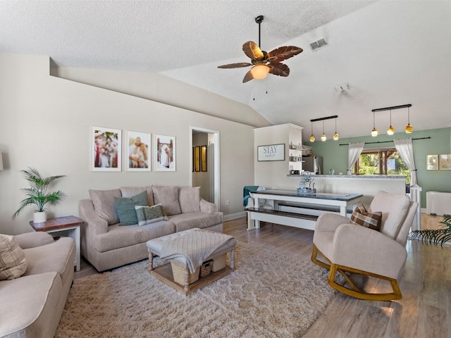 living room with radiator heating unit, wood finished floors, visible vents, a ceiling fan, and a textured ceiling