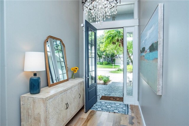 entryway with a chandelier, french doors, and light hardwood / wood-style floors