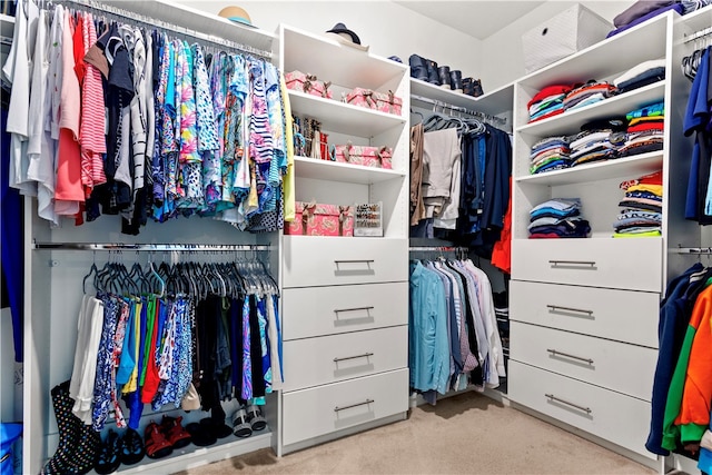 walk in closet featuring light carpet