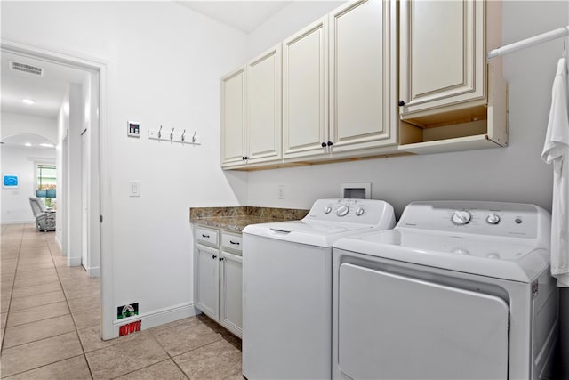 washroom featuring cabinets, washer and dryer, and light tile patterned floors