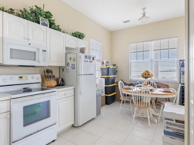 kitchen featuring white appliances, white cabinetry, and light tile patterned flooring