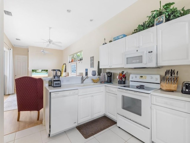 kitchen with white cabinets, white appliances, sink, and light tile patterned floors