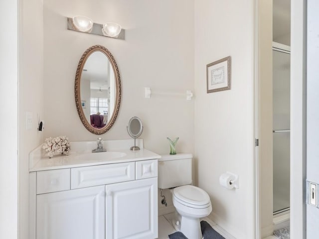 bathroom with tile patterned flooring, vanity, an enclosed shower, and toilet