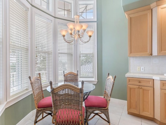 dining space with light tile patterned floors, a wealth of natural light, and an inviting chandelier